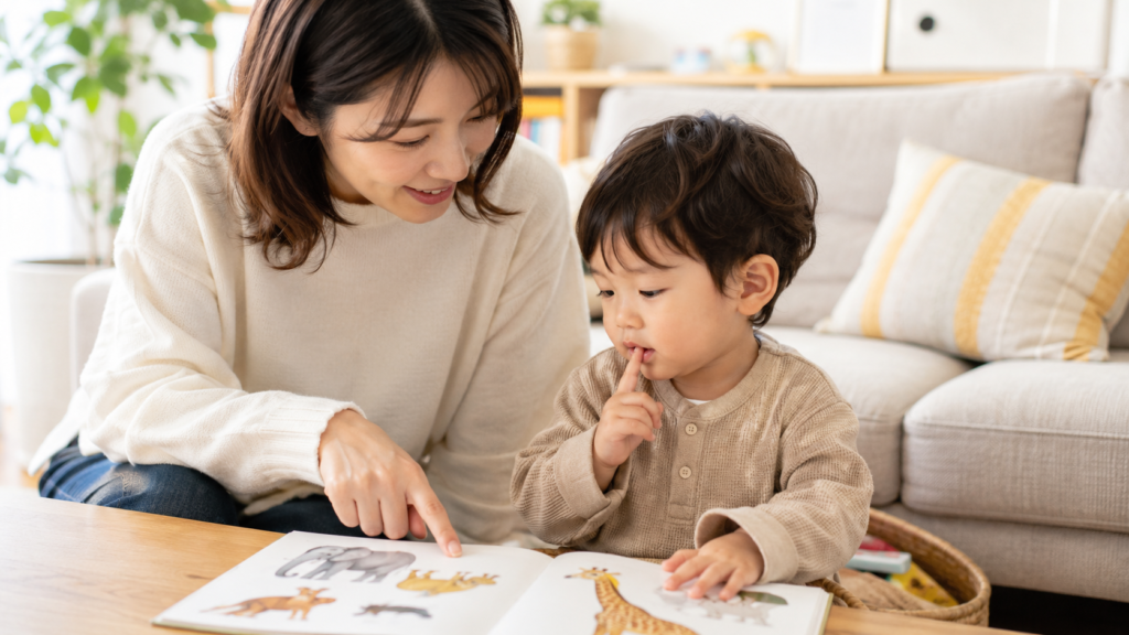 alt="親子で絵本を見ながら言葉のやりとりをしている様子"